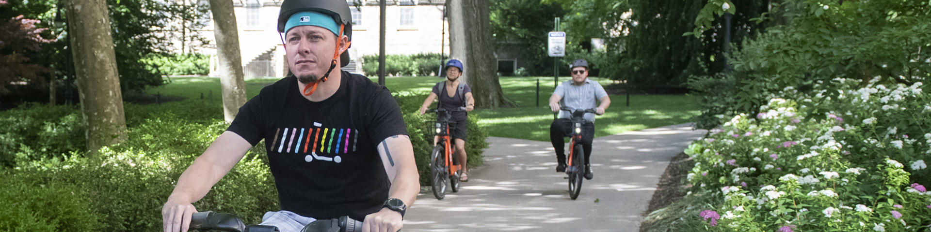 Penn Staters riding Spin e-bikes on campus.