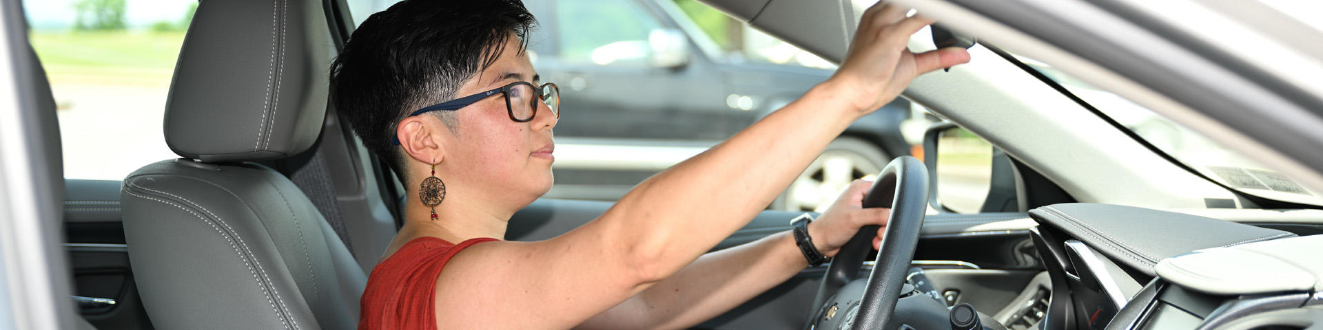 Driver adjusting rearview mirror