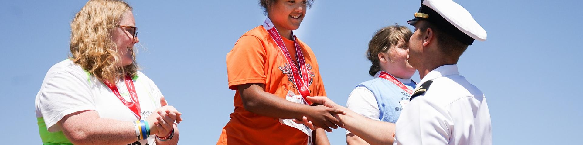 Special Olympics Athletes receiving medals at an award ceremony 