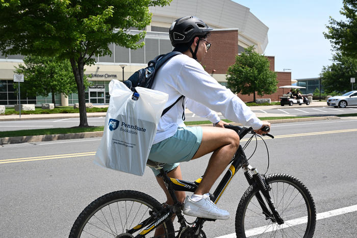 Student biking near the Bryce Jordan Center