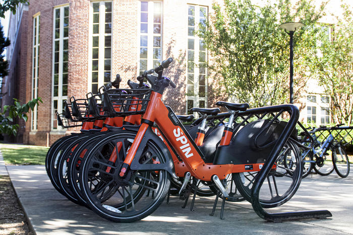 Spin e-bikes lined up on a bike rack